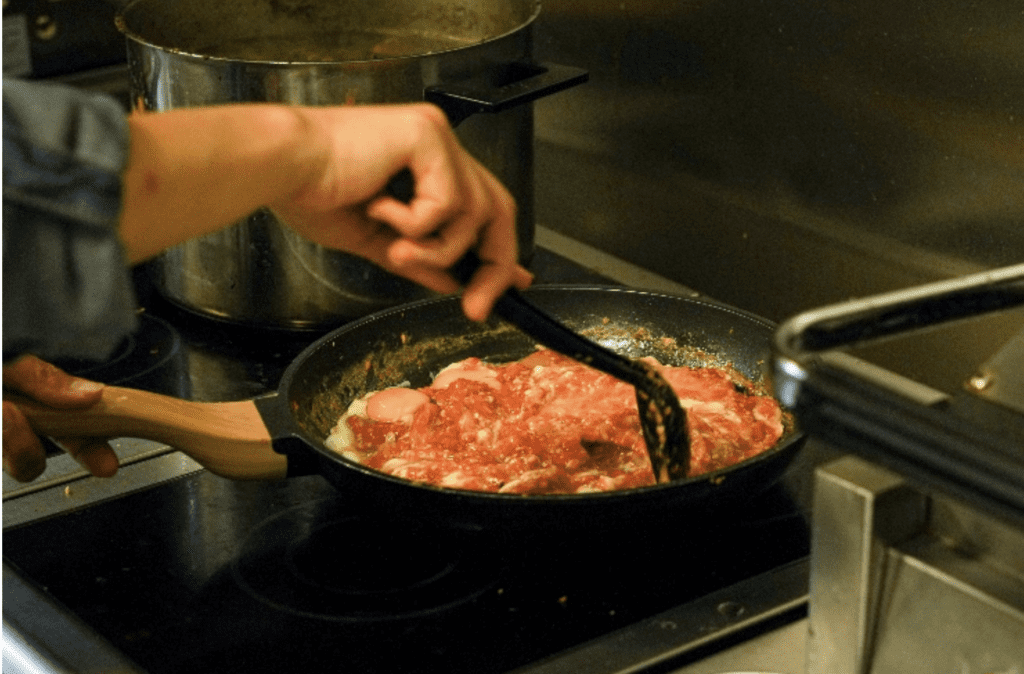 Chef cooking food on a stove at Star of Greenwich