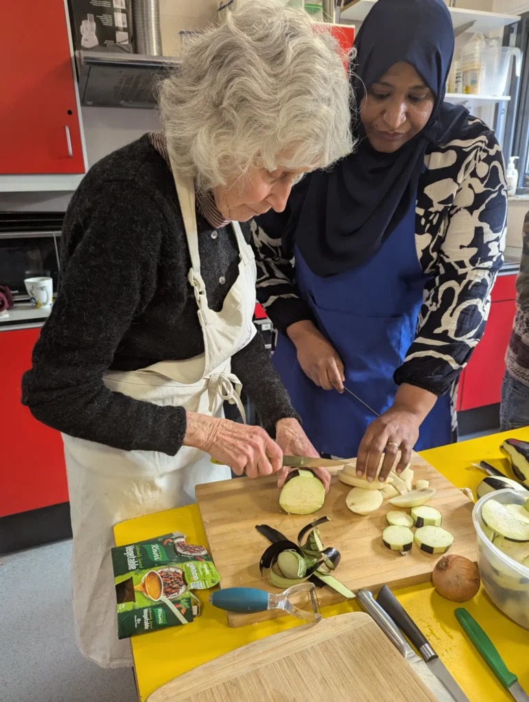 Plateful Cafe cooking class two students chopping vegetables