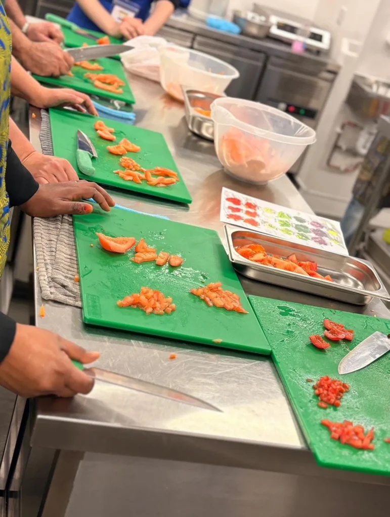 Students chopping vegetables at Plateful Cafe training class