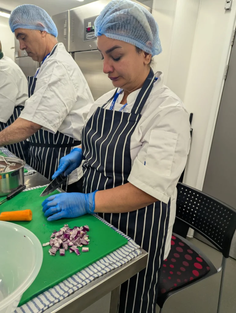 Plateful Cafe student chopping vegetables
