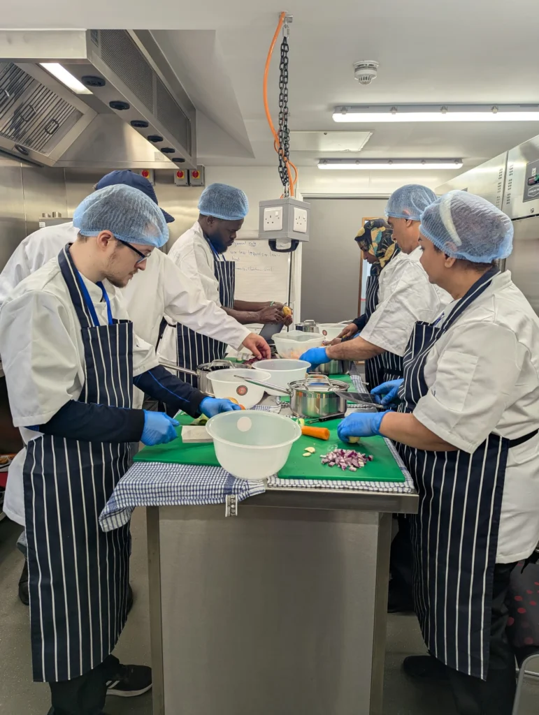 Plateful Cafe students chopping vegetables