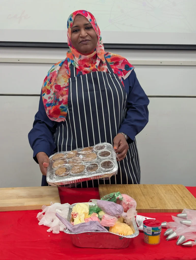 Maysoon holding a tray of cakes
