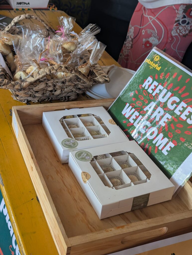 A stand selling sweets and showing a sign saying "refugees are welcome"
