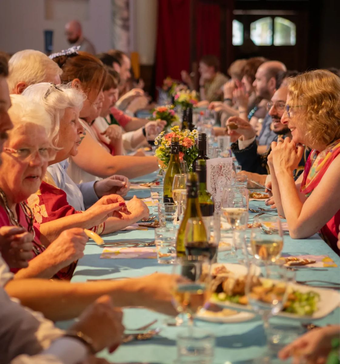 Guests sharing a Plateful Café community meal at a long table